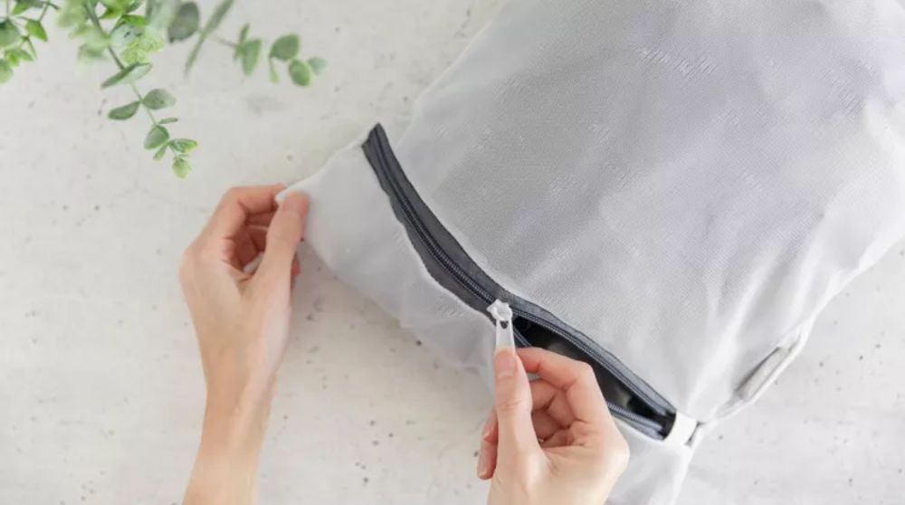 Đặt áo gió vào túi giặt