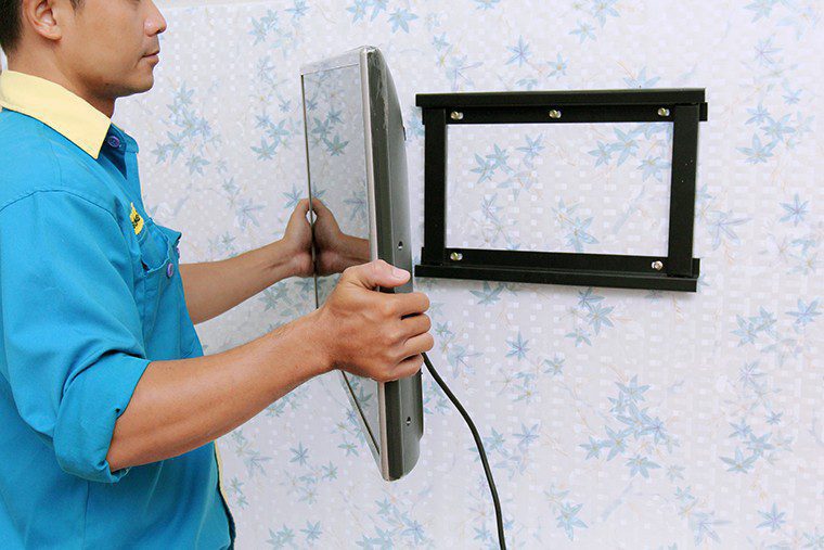 Đặt tivi lên khung treo. Đặt tivi lên khung treo.