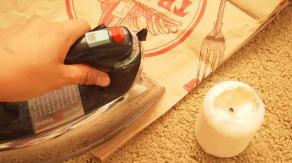 dùng bàn ủi loại bỏ vết sáp nến trên thảm