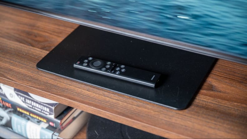 Chân đế TV Samsung QN90B với điều khiển từ xa phía trên.